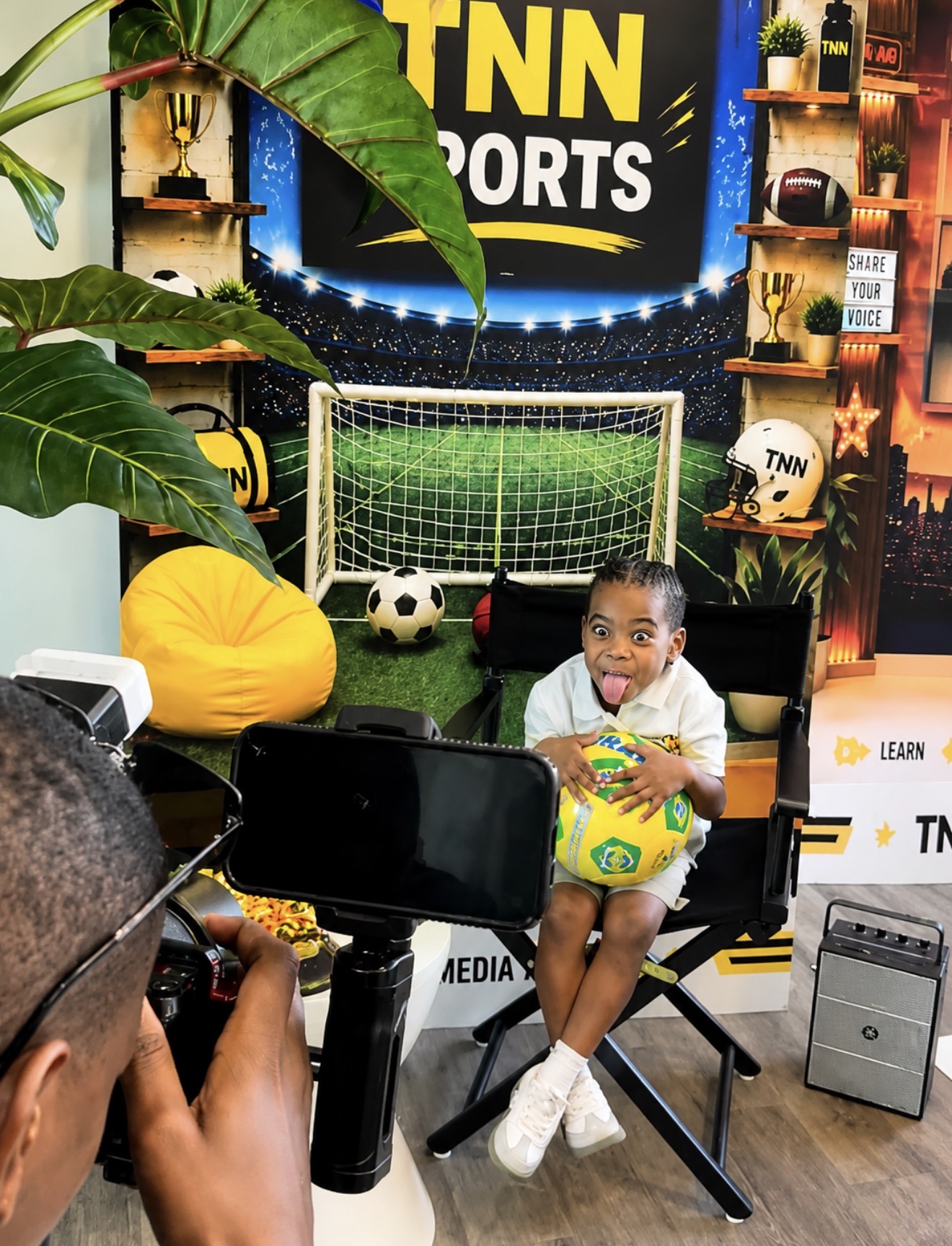 TNN Media Academy student on the TNN Sports set holding a soccer ball while being filmed